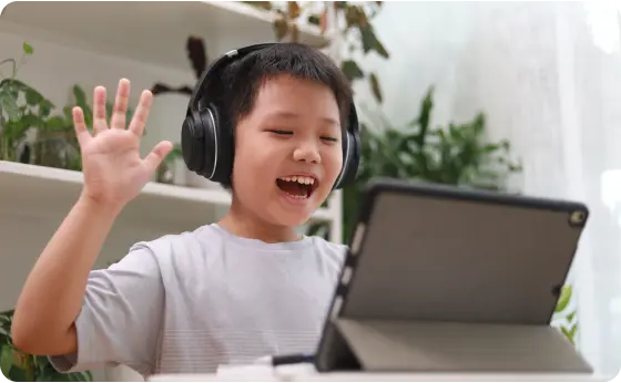 Elementary student waiving at his online class