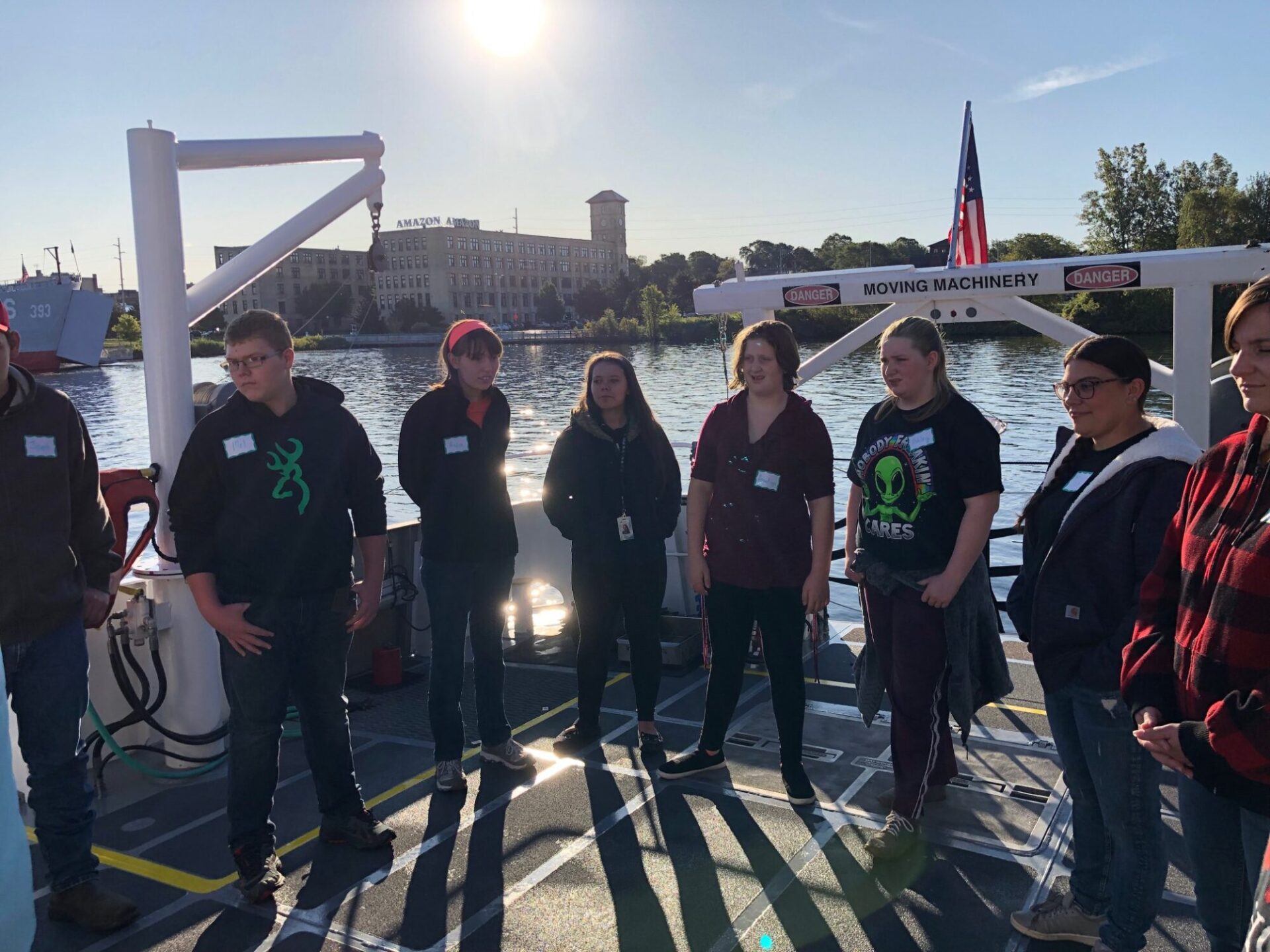 A group of people standing on the deck of a boat