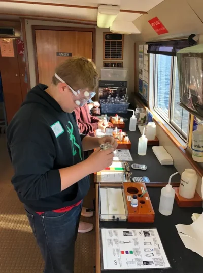 a person wearing goggles and standing in front of a table with equipment