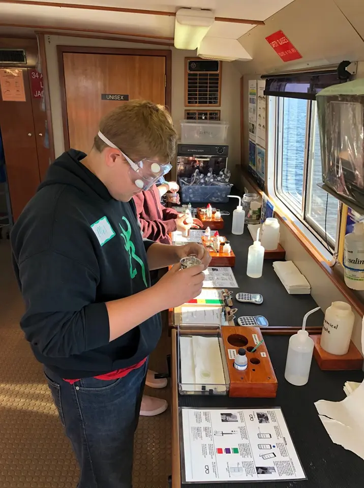 a person wearing goggles and standing in front of a table with equipment