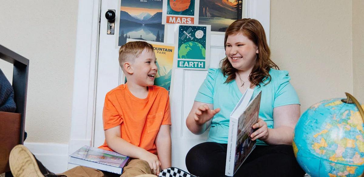 girl and little boy smiling and learning